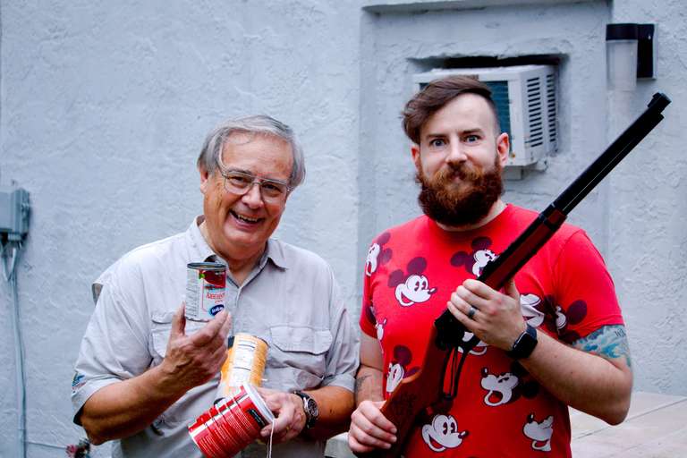 Dan stands next to son Jonathan who's holding a bb gun for target practice.