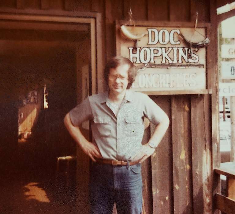 Dan Hopkins standing, hands on hips, in front of his frontiersman shop in Tennessee.