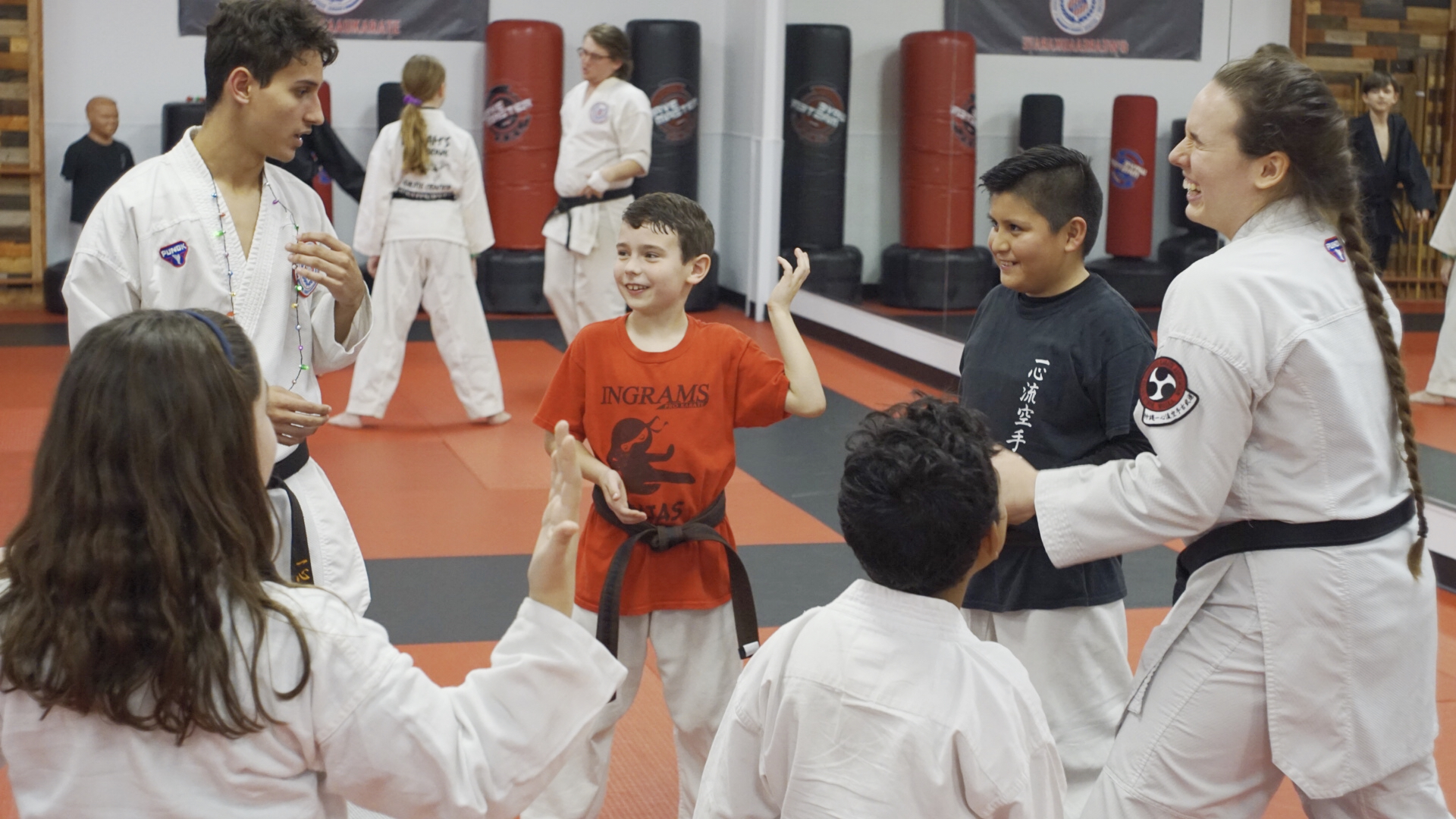 Students play "Ninja Tag" with teen sensei in a circle.